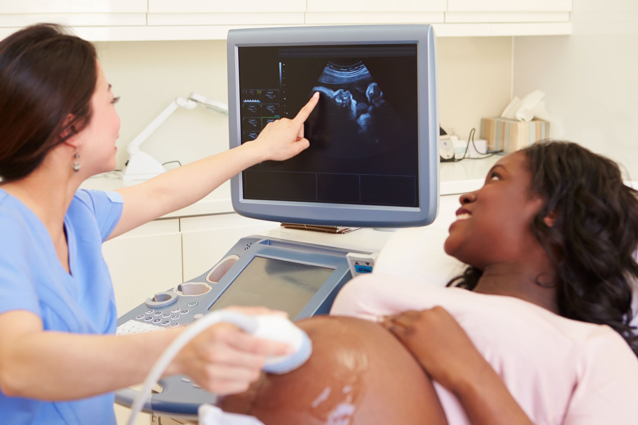 Sonographer with an soon to be mother conducting an ultrasound